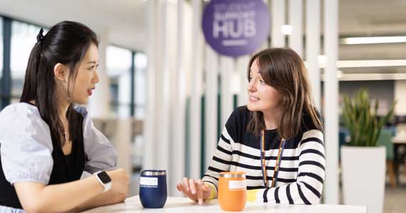 two ladies sat at a table talking